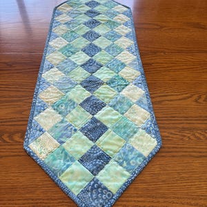 Blue + aqua colorful patchwork table runner.  It was quilted with a decorative stitch. A pop of color for your table.  11 by 34 inches long