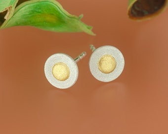 Circular pair of stud earrings with a fine gold dot