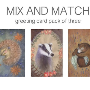Puede incluir: Un conjunto de tres tarjetas de felicitación con ilustraciones de acuarela de un erizo, un tejón y un oso. El erizo está durmiendo sobre un fondo azul y blanco con flores naranjas. El tejón está en una corona marrón y verde con flores rosas. El oso está durmiendo sobre un fondo marrón y naranja con flores azules y moradas.