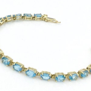 11.22 Carat Blue Topaz 14 Karat Yellow Gold Ladies Tennis Bracelet, 7" Long