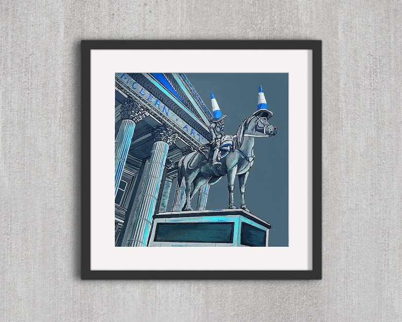 May include: A framed art print featuring a whimsical illustration of a statue of a horse and rider, both adorned with traffic cones. The background shows a building with the words "MODERN ART" in blue. The artwork is set against a gray backdrop.