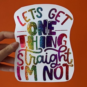 May include: A rainbow glitter sticker with the text "Let's get one thing straight I'm not".