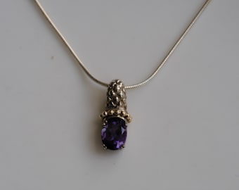 May include: A silver chain necklace with a pendant featuring a purple amethyst gemstone set in a gold and silver setting.