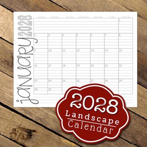 May include: A white 2028 January calendar with a red and white label that says "2028 Landscape Calendar." The calendar is on a wooden surface. The word "January" and the year "2028" are written vertically on the left side of the calendar.