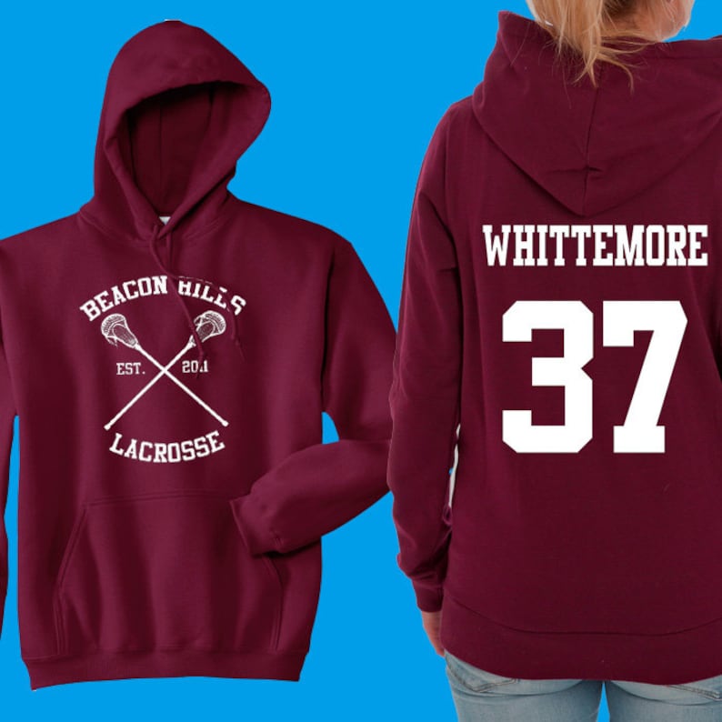 May include: Burgundy hooded sweatshirt with a white lacrosse stick design on the front and the text "Beacon Hills Est. 2014 Lacrosse" and the text "Whittemore 37" on the back.