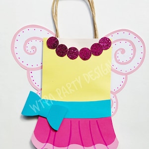 May include: A yellow paper bag with a pink and blue fairy dress design. The bag has a pink glitter necklace and a blue bow. The bag has a brown string handle and is decorated with white polka dots.