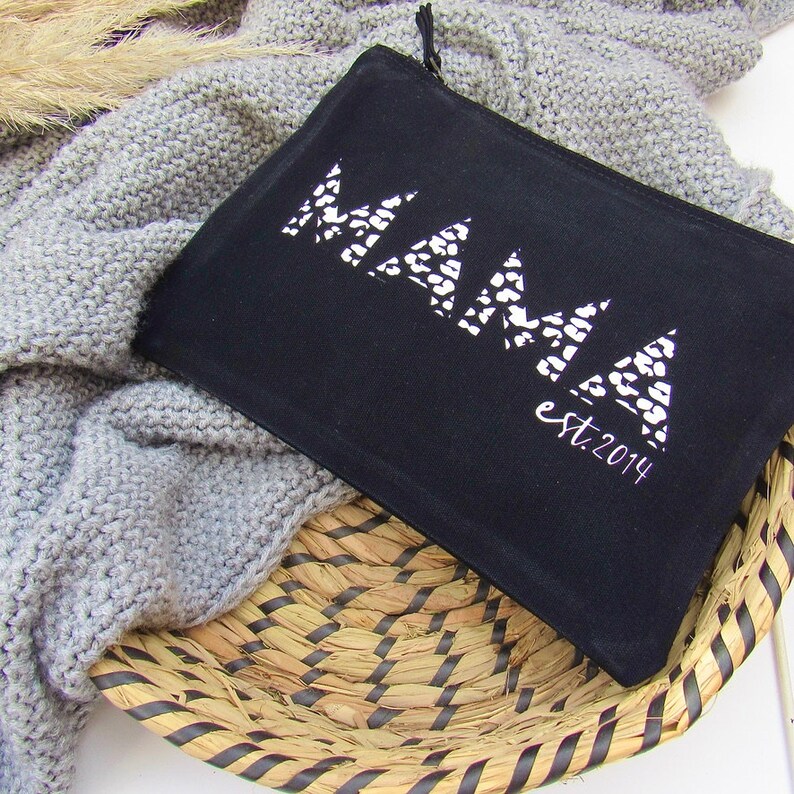 May include: Black canvas zippered pouch with a white geometric design that says "MAMA est. 2014".