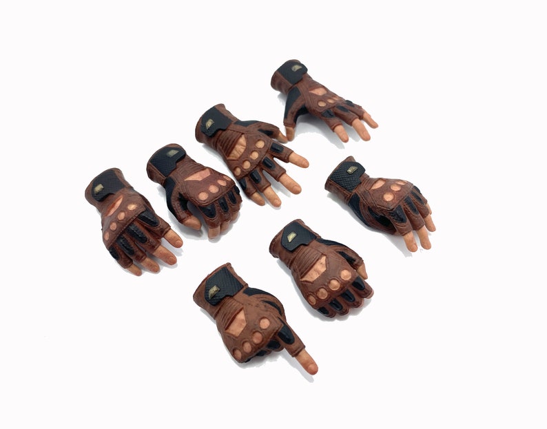 May include: Set of eight brown leather gloves with black accents and fingerless design. The gloves have a textured surface and are arranged in a pattern on a white background.