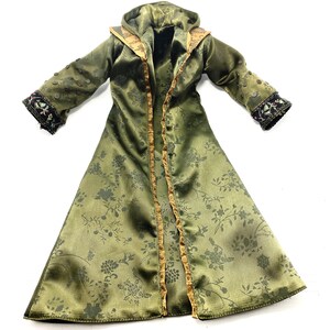 Op de afbeelding: Een lange groene satijnen robe met een bloemenpatroon, gouden bies en een capuchon. De robe heeft een decoratief ontwerp op de mouwen.