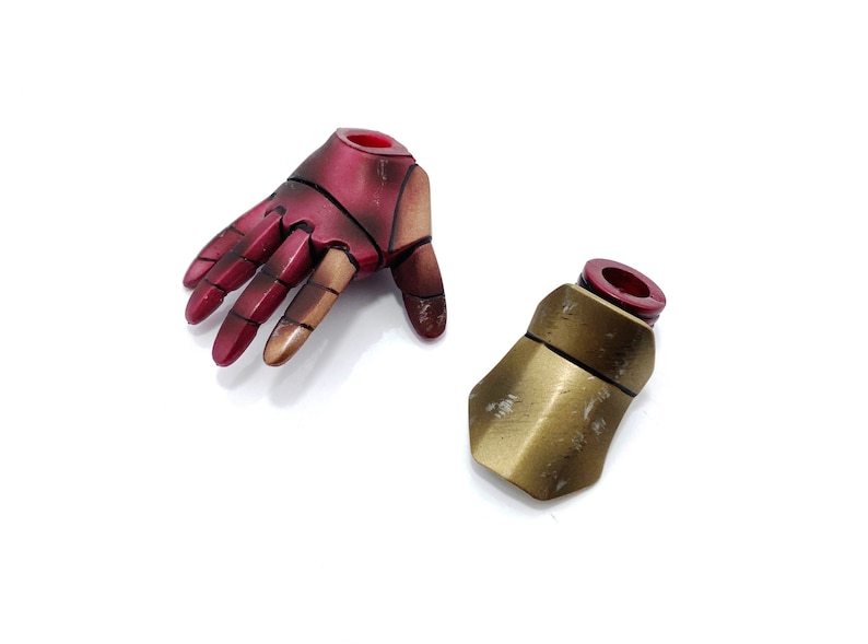 May include: Two action figure accessories, a red and gold hand and a gold forearm, both with a red plastic connector.