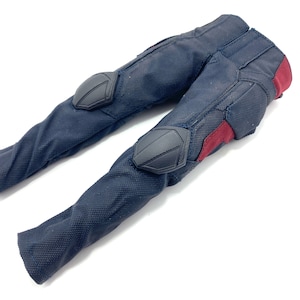 May include: Black trousers with red and black accents. The trousers have knee pads and are made of a textured fabric.