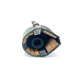 May include: A green and brown helmet with a black lens. The helmet is open and the inside is visible. The inside of the helmet is made of brown and black material.