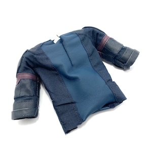 Puede incluir: Una camisa de manga corta de color azul oscuro y negro con una tela texturizada. La camisa tiene una cremallera en la espalda y un ribete negro y morado en las mangas.