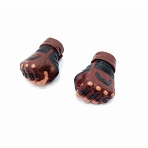 Op de afbeelding: Een paar bruine leren vingerloze handschoenen met zwarte accenten en knokkelbescherming.