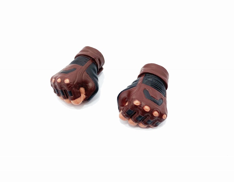 Op de afbeelding: Een paar bruine leren vingerloze handschoenen met zwarte accenten en knokkelbescherming.