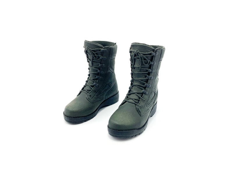 May include: A pair of dark green military-style boots with black laces. The boots are made of a textured material and have a rugged sole.