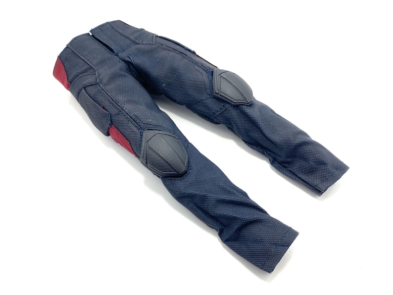 May include: Black trousers with red accents and black knee pads. The trousers are made of a textured fabric.