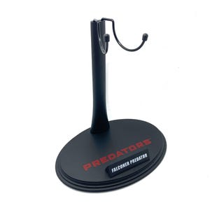 May include: Black plastic action figure stand with a hook for hanging. The base has the words "PREDATORS" and "FALCONER PREDATOR" printed in red.