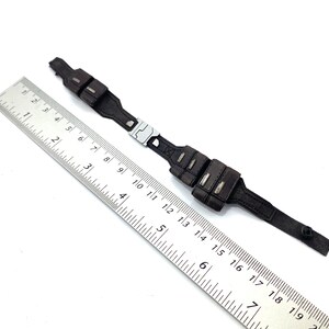 May include: A black leather belt with two pouches on each side. The belt is approximately 16 inches long.