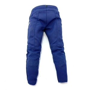 May include: A pair of dark blue denim trousers with knee pads. The trousers have a straight leg and a zip fly.