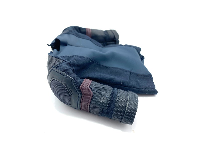 Puede incluir: Una camisa de manga larga azul oscuro y negra con un codo acolchado y un acento burdeos. La camisa est&aacute; hecha de una tela suave y texturizada.