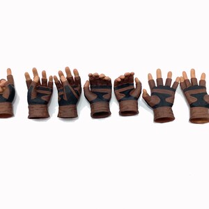 May include: Eight brown leather gloves with black accents. The gloves have different hand poses, including pointing, open palm, and fist.