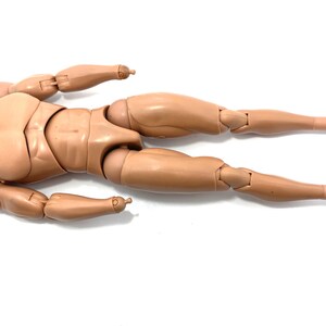 May include: A tan-colored articulated action figure body, lying horizontally. The figure has a detailed, realistic design with visible joints at the elbows, knees, and other points. The feet have black bands. The figure is designed for customization.