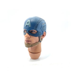 Op de afbeelding: Een gedetailleerde hoofdsnede van Captain America, met een blauwe helm met de letter "A" en een masker. De figuur heeft realistische huidtinten en een gebruinde nek. Een verzamelobject.