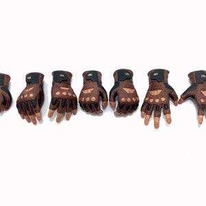 May include: Seven brown leather gloves with black accents and finger holes. The gloves are arranged in a row on a white background.