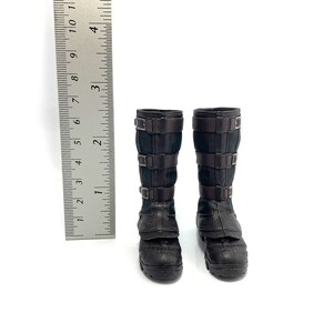 May include: A pair of black leather boots with buckles. The boots are approximately 18 cm tall and have a pointed toe.