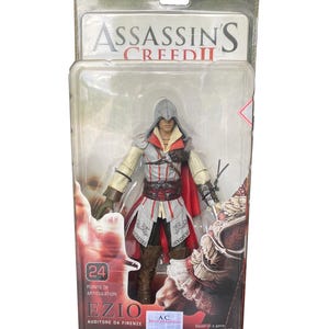 May include: Assassin's Creed II action figure of Ezio Auditore da Firenze, packaged in a clear plastic case. The figure has 24 points of articulation and features a retractable and removable blade. The packaging includes the text "Game Available 11.16.10".