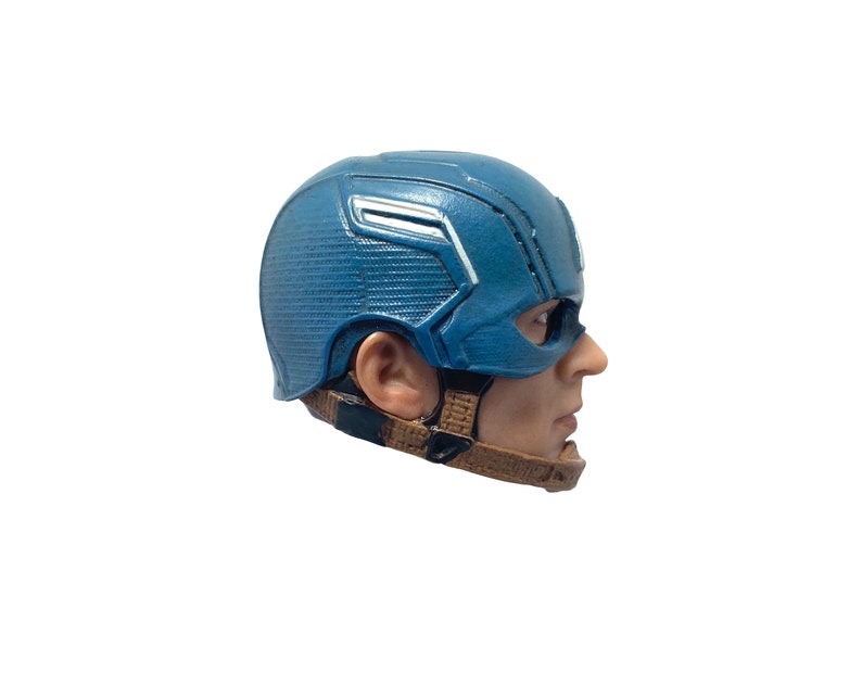 Puede incluir: Un casco de Capit&aacute;n Am&eacute;rica de pl&aacute;stico azul y blanco con una correa marr&oacute;n. El casco lo lleva puesto una persona, pero solo se ve el lado de la cara.