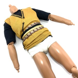 May include: A brown and black action figure wearing a yellow shirt, a brown and black belt, and white underwear.