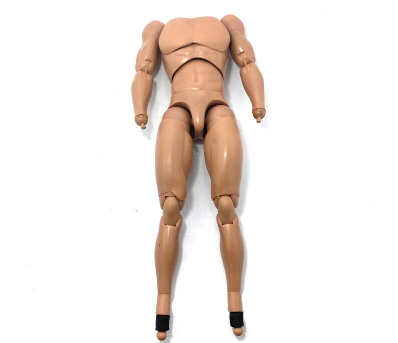 May include: Tan-colored action figure body with articulated joints. The figure has a muscular physique, with defined arms, chest, and legs. The feet have black ankle supports. The figure is designed to be customizable.