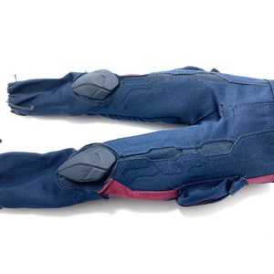 Puede incluir: Pantal&oacute;n azul con detalles rojos y rodilleras negras. El pantal&oacute;n tiene un cord&oacute;n en la cintura y un bolsillo en la pierna derecha.