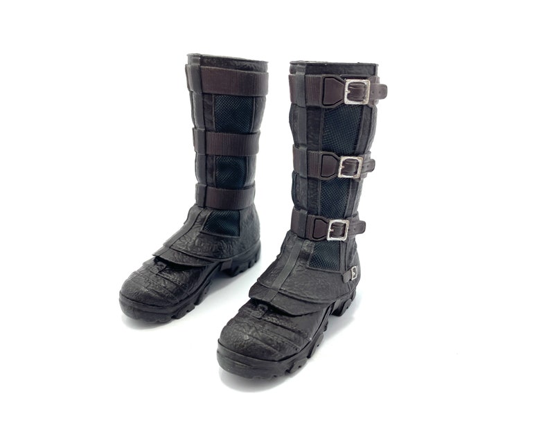 May include: A pair of brown leather boots with multiple buckles. The boots have a textured surface and a pointed toe.