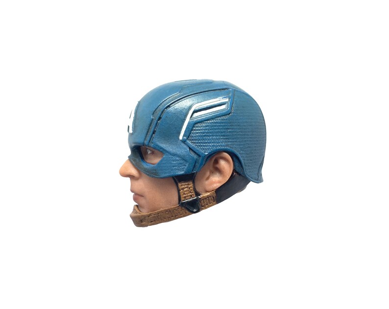Puede incluir: Un casco de pl&aacute;stico azul y blanco de Capit&aacute;n Am&eacute;rica con una correa marr&oacute;n. El casco est&aacute; dise&ntilde;ado para parecerse al que usa el superh&eacute;roe en las pel&iacute;culas de Marvel.