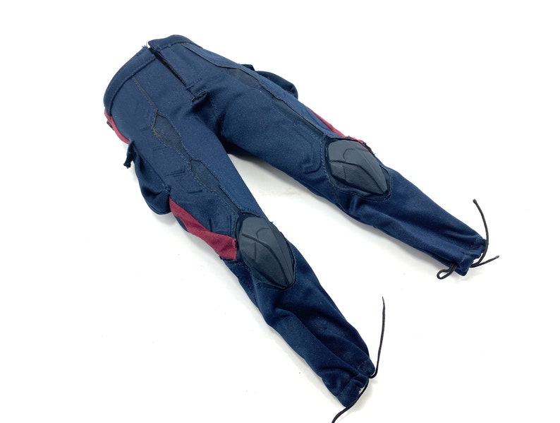 Puede incluir: Pantal&oacute;n azul con detalles rojos y negros. El pantal&oacute;n tiene rodilleras y un cord&oacute;n de ajuste en la parte inferior.