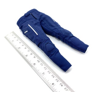 May include: Blue trousers with knee pads and white accents. The trousers are made of a durable fabric and have a zip fly.