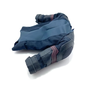 Puede incluir: Una chaqueta de tela azul oscuro y negro con cierre de cremallera y un panel de malla en el codo. La chaqueta tiene una tela texturizada y un acento burdeos en el codo.
