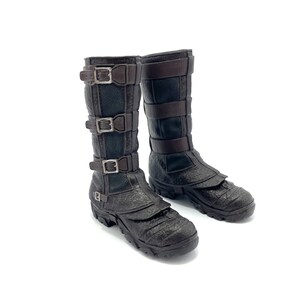 May include: A pair of brown leather boots with multiple buckles. The boots have a textured surface and a thick sole.