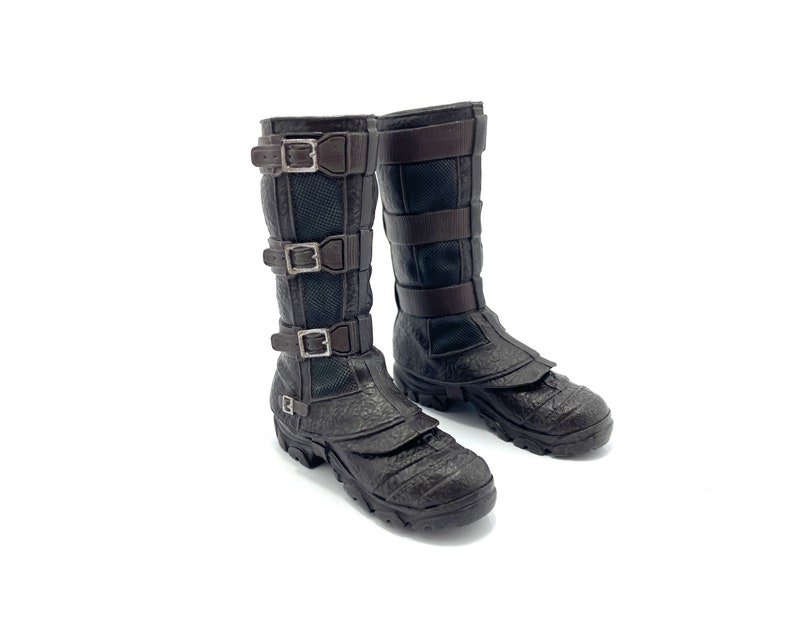 May include: A pair of brown leather boots with multiple buckles. The boots have a textured surface and a thick sole.