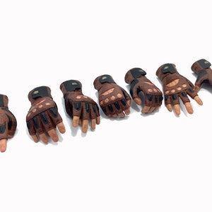 May include: Seven brown leather fingerless gloves with black accents and knuckle padding.