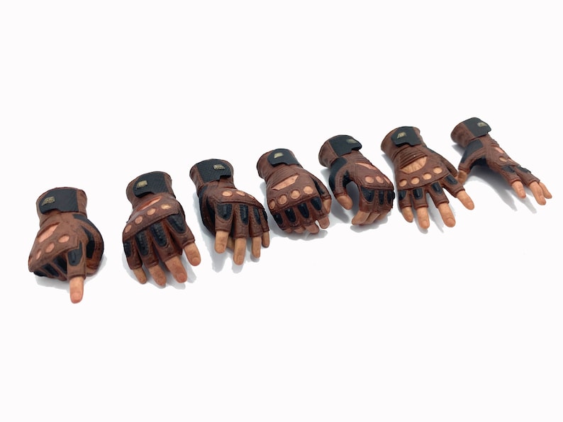 May include: Seven brown leather fingerless gloves with black accents and knuckle padding.