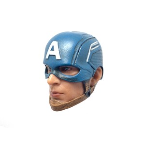 Puede incluir: Una cabeza de pl&aacute;stico azul y blanco de Captain America con una correa de barbilla marr&oacute;n. La cabeza es una figura coleccionable.