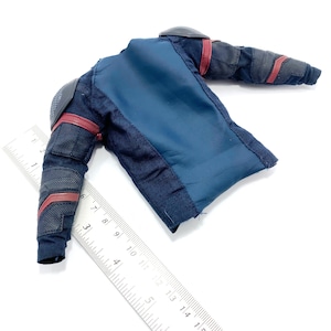 Op de afbeelding: Een blauw en zwart actieve figuurjack met rode accenten. Het jack heeft een ritssluiting en een opstaande kraag.