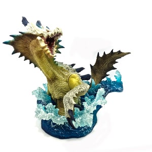 May include: A detailed figurine of a sea dragon emerging from stylized blue and white waves. The dragon has a light green body, white teeth, and dark blue accents. The figurine is set against a white background.