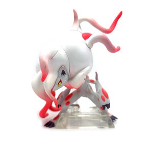 Puede incluir: Una figura blanca y gris con detalles en rojo, que representa una criatura en una pose din&aacute;mica. La figura tiene un dise&ntilde;o estilizado con manchas rojas y cuernos curvos. Sobre un fondo blanco.