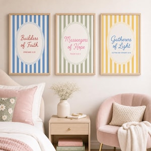 May include: Three framed art prints with inspirational quotes. Each print features a vertical striped background in blue, green, and yellow, with an oval containing text. The quotes are "Builders of Faith," "Messengers of Hope," and "Gatherers of Light."