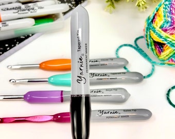 Puede incluir: Primer plano de un marcador permanente gris con tapa negra y punta biselada. El marcador está etiquetado como "Yarnie Tapered Tip Permanent Maker".